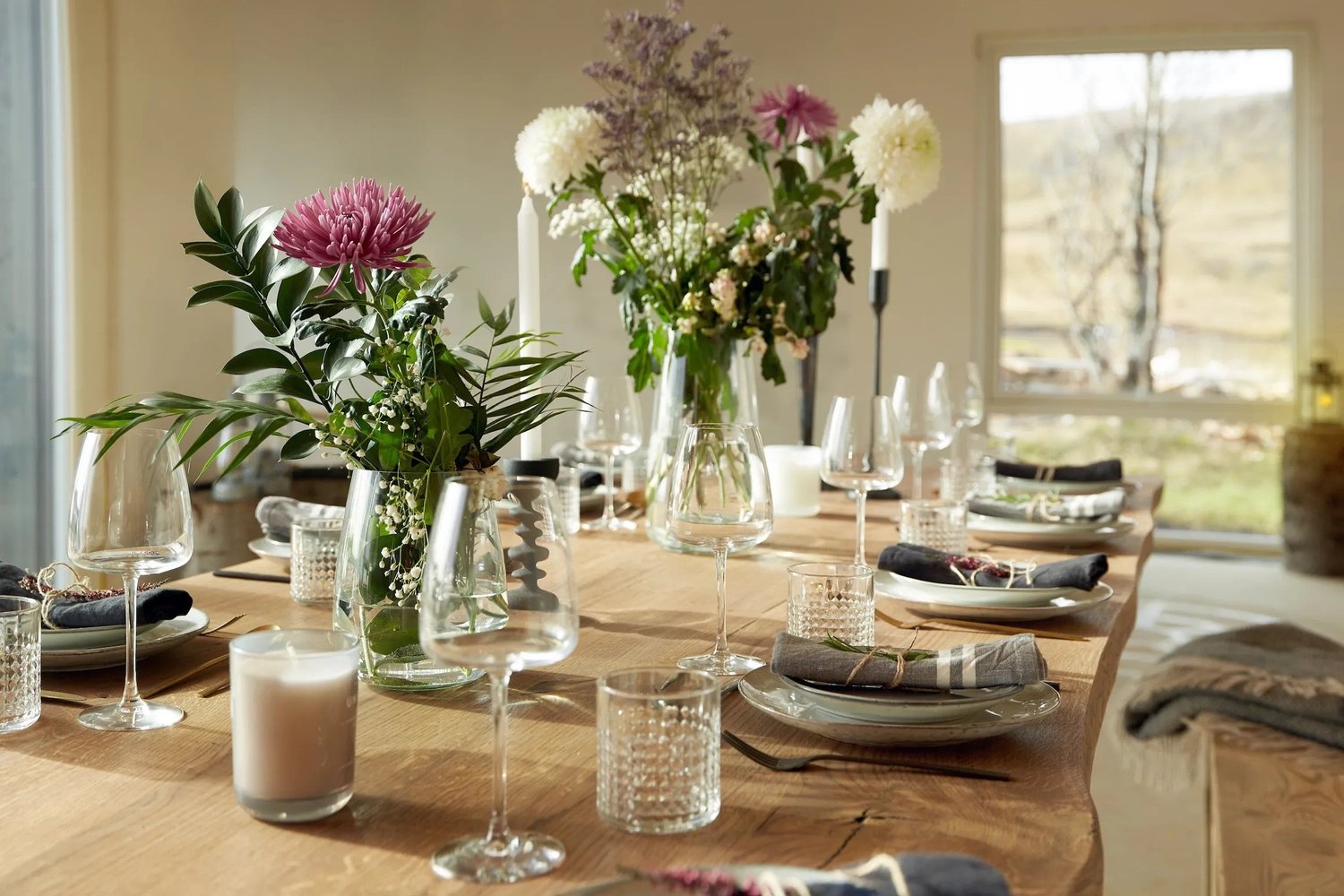 A long dinner table set with candles